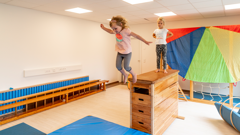 Kind springt ueber Springbock im Innenbereich, Albertinen Kindertagesstätte Schnelsen, Hamburg