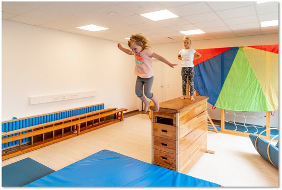 Zwei Kinder springen von einem Springbock auf eine Matte in einem Multifunktionsraum in der Albertinen Kindertagesstätte Schnelsen in Hamburg.